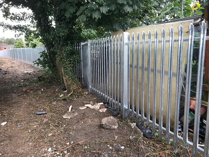 Galvanised palisade fence installed alongside a building